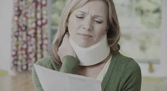 A lady with a neck brace in pain holding a letter